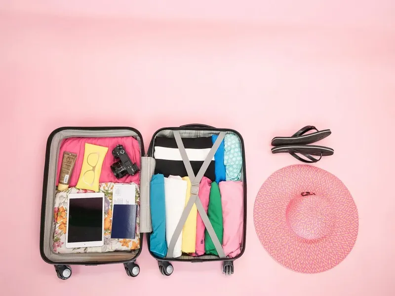 Neatly packed suitcase with clothes, gadgets, and travel accessories.”
               title=